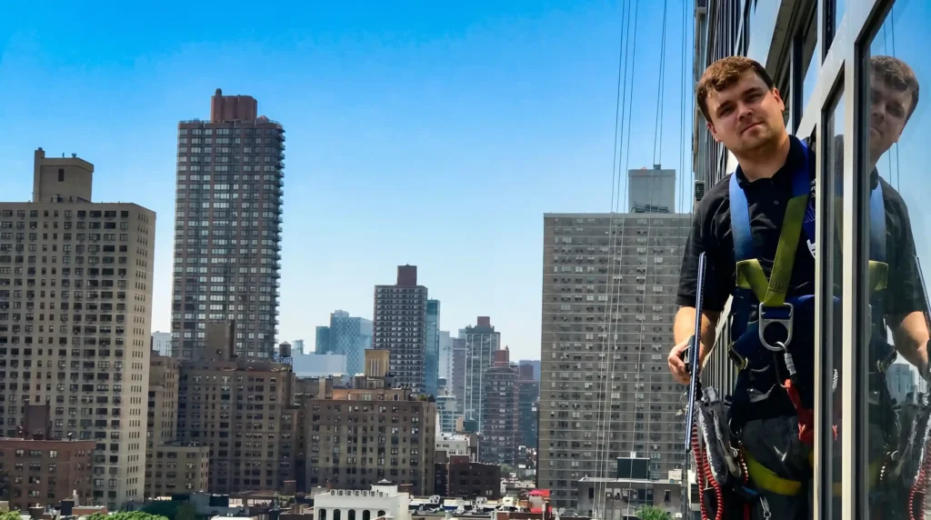 Big Apple Window Cleaning company technician working on commercial high-rise window cleaning in New York