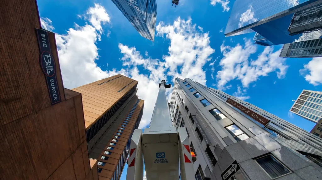 Truck-mounted aerial lift reaching high rise windows between buildings in New York City