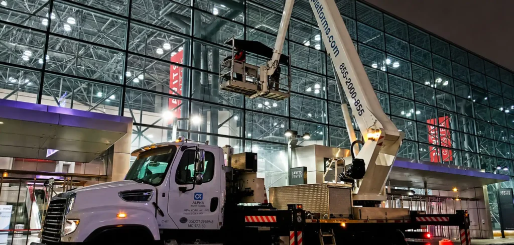 Truck-mounted aerial lift used at night for corporate building window cleaning in New York