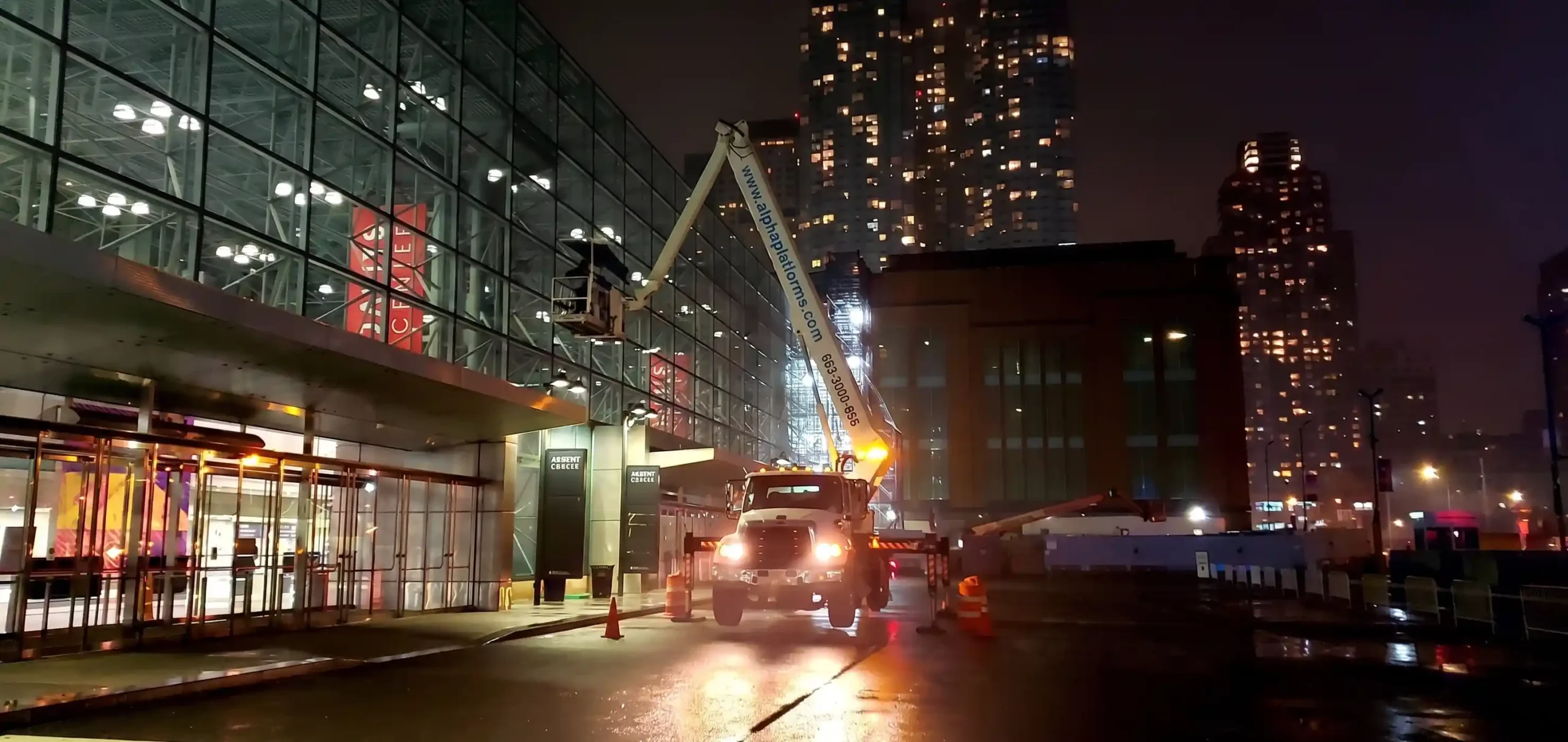 Boom lift set up at night for commercial window washing on a New York City building