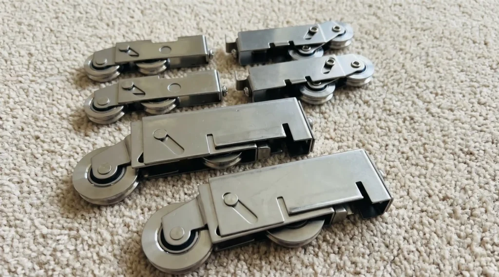 Several different sliding door roller wheel assemblies showing varied sizes and mounting styles