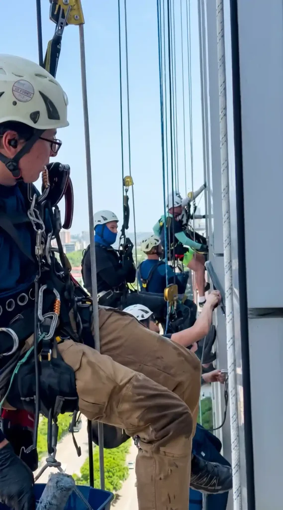 Rope access window cleaning team working on a high rise building facade