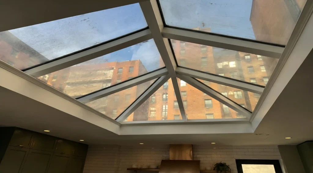 Dirty roof lantern glass viewed from inside a room, with urban grime reducing clarity and natural light.