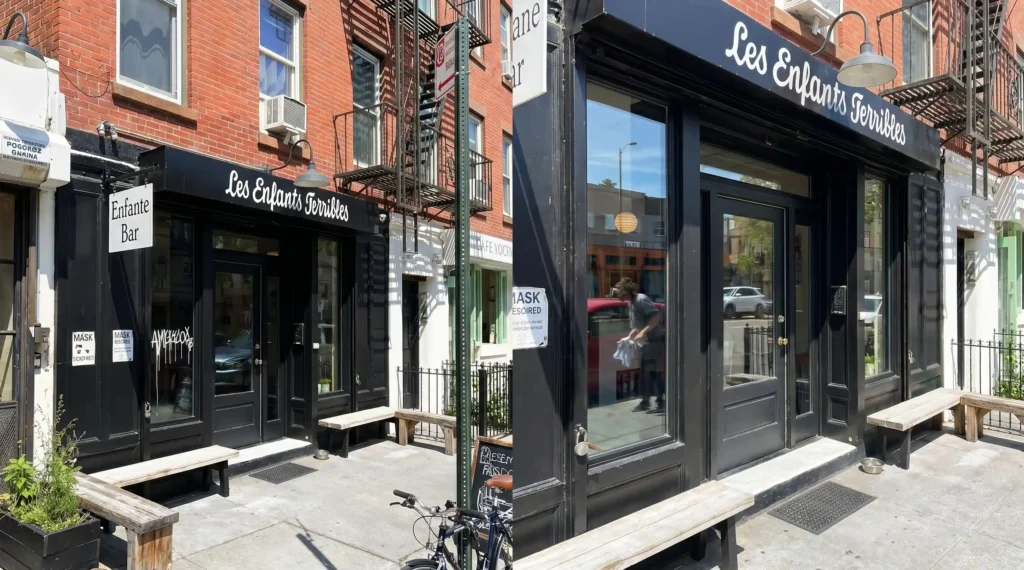 Before and after graffiti removal from a Manhattan restaurant storefront showing a spray paint tag cleaned from the window glass