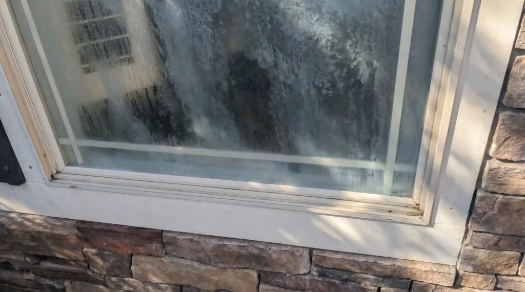 Foggy house window with failed insulated glass seal before repair or replacement